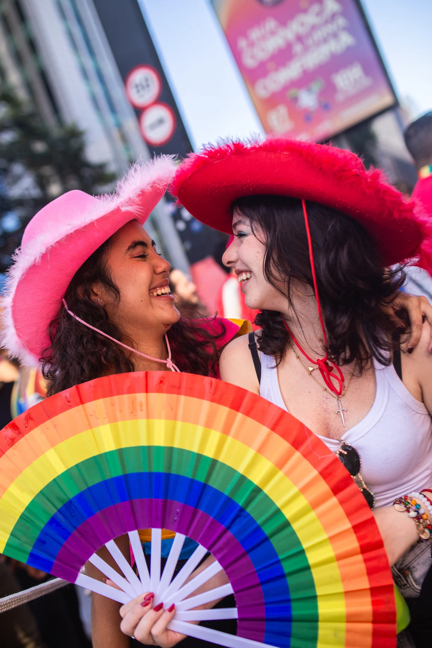 Duas pessoas celebram com um leque nas cores do arco-íris